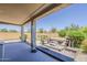 Spacious covered patio with a hot tub, lush landscaping, and a serene outdoor setting at 27413 W Tonopah Dr, Buckeye, AZ 85396