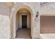 Close-up of home entrance with arched doorway, address numbers, and stucco facade at 27413 W Tonopah Dr, Buckeye, AZ 85396