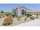 Desert landscaping in front yard of beige stucco home featuring a tile roof and large window at 27413 W Tonopah Dr, Buckeye, AZ 85396