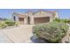 Beige stucco home with tile roof, two-car garage, driveway, and desert landscaping at 27413 W Tonopah Dr, Buckeye, AZ 85396