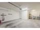 Open garage space with overhead lighting, a service door, and practical shelving for storage solutions at 27413 W Tonopah Dr, Buckeye, AZ 85396