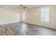 Light-filled living room with wood-look floors, ceiling fan, and windows with blinds at 27413 W Tonopah Dr, Buckeye, AZ 85396