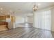 Open-concept living area featuring wood-style flooring, sliding glass doors, and kitchen access at 27413 W Tonopah Dr, Buckeye, AZ 85396