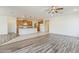 Open-concept living area with wood-look floors, flowing into kitchen with tile flooring at 27413 W Tonopah Dr, Buckeye, AZ 85396