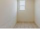 Simple tiled room offers a neutral space, illuminated by a window, ideal for versatile use at 27413 W Tonopah Dr, Buckeye, AZ 85396