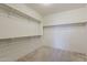 A spacious walk-in closet offers ample storage space with metal rods for hanging clothes at 27413 W Tonopah Dr, Buckeye, AZ 85396