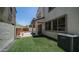 Lush backyard featuring artificial grass, a built-in bench, a patio, and a modern AC unit at 31653 N 24Th Dr, Phoenix, AZ 85085