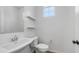 Clean, simple powder room with pedestal sink, toilet, floating shelves and a window at 31653 N 24Th Dr, Phoenix, AZ 85085