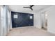 A neutral carpeted bedroom with 3 windows, a dark blue accent wall, and a ceiling fan at 31653 N 24Th Dr, Phoenix, AZ 85085
