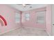 Bright bedroom featuring a charming rainbow graphic, neutral carpet, and multiple windows at 31653 N 24Th Dr, Phoenix, AZ 85085