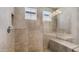 Walk-in shower featuring neutral tile, a built-in bench, and glass enclosure at 31653 N 24Th Dr, Phoenix, AZ 85085