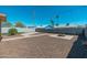 Spacious backyard featuring rockscape, palm trees, privacy wall, and a built-in firepit at 3231 W Banff Ln, Phoenix, AZ 85053