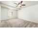 Bright bedroom with neutral carpet, ceiling fan, and natural light from a window at 3231 W Banff Ln, Phoenix, AZ 85053