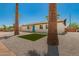 Inviting single-story home featuring a blue door, with manicured stone landscaping and tall palm trees at 3302 N 40Th Dr, Phoenix, AZ 85019