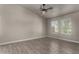 Bright bedroom with wood-look tile flooring, two large windows providing natural light, and neutral wall paint at 34970 N Spur Cir, San Tan Valley, AZ 85144