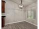 This dining room features wood-look tile flooring, white trim, a modern chandelier, and a window at 34970 N Spur Cir, San Tan Valley, AZ 85144