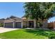 Charming home with a three-car garage, neat landscaping, and a vibrant green lawn, offering suburban comfort at 34970 N Spur Cir, San Tan Valley, AZ 85144