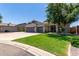 Well-kept home boasts a three-car garage, tidy landscaping, and a lush green lawn in a quiet suburban setting at 34970 N Spur Cir, San Tan Valley, AZ 85144