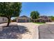 Spacious home featuring a three-car garage, long driveway, with well-manicured lawns, and mature trees at 34970 N Spur Cir, San Tan Valley, AZ 85144