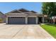 Inviting single-story home with a spacious three-car garage, tidy landscaping, and a well-maintained lawn at 34970 N Spur Cir, San Tan Valley, AZ 85144