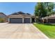 Attractive home with a three-car garage, wide driveway, manicured lawn, and mature trees in a residential neighborhood at 34970 N Spur Cir, San Tan Valley, AZ 85144