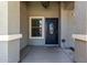 Cozy covered front porch with decorative door, sidelight window, and textured stucco exterior finish at 34970 N Spur Cir, San Tan Valley, AZ 85144