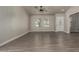 Spacious living room featuring wood-look tile flooring, ample natural light from large windows, and a welcoming entryway at 34970 N Spur Cir, San Tan Valley, AZ 85144