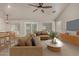 Comfortable living room furnished with sectional sofa, wood-look floors, and seamless transitions to dining, perfect for gathering at 34970 N Spur Cir, San Tan Valley, AZ 85144