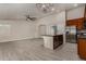 Open concept living room boasts wood-look tile, neutral paint, and opens to the kitchen at 34970 N Spur Cir, San Tan Valley, AZ 85144