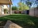 A well-maintained backyard with green grass, vibrant shrubbery, a storage shed, and block wall for privacy at 351 S Apache Dr, Chandler, AZ 85224