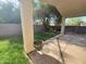 A serene backyard featuring a covered patio, lush green lawn, and mature shade trees for relaxation and outdoor enjoyment at 351 S Apache Dr, Chandler, AZ 85224