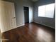This bedroom features dark wood floors and a window with horizontal blinds at 351 S Apache Dr, Chandler, AZ 85224