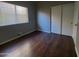 This bedroom features dark wood floors and a closet with white sliding doors at 351 S Apache Dr, Chandler, AZ 85224
