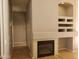 Living room with a cozy fireplace, tile flooring, and custom built-in shelving at 351 S Apache Dr, Chandler, AZ 85224