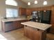 Bright kitchen boasts wooden cabinets, stainless appliances, a central island and tile flooring at 351 S Apache Dr, Chandler, AZ 85224