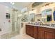 A bathroom featuring a glass enclosed shower, double sink granite vanity, and neutral colored walls at 3823 E Kroll Dr, Gilbert, AZ 85234