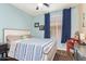 A bedroom with blue accent wall, wood-look flooring, and white furniture at 3823 E Kroll Dr, Gilbert, AZ 85234