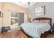 A bedroom featuring a wooden bed frame, wood laminate flooring, neutral colored walls, and a sliding glass door at 3823 E Kroll Dr, Gilbert, AZ 85234