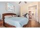 A bedroom featuring a wooden bed frame, wood laminate flooring, neutral colored walls, and ceiling fan at 3823 E Kroll Dr, Gilbert, AZ 85234