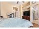 A bedroom featuring a wooden bed frame, wood laminate flooring, neutral colored walls, and a television at 3823 E Kroll Dr, Gilbert, AZ 85234