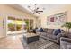 Bright living room with a ceiling fan, a comfortable sofa, and sliding glass doors to the patio at 3823 E Kroll Dr, Gilbert, AZ 85234