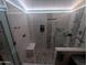 This frameless glass shower features dual showerheads, built-in niches, and contemporary design at 3823 E Kroll Dr, Gilbert, AZ 85234