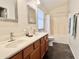 Bathroom features double sinks, wood cabinets, and shower-tub combo with a tile surround at 4002 E Agave Rd, Phoenix, AZ 85044