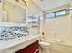 Bathroom with updated vanity, colorful tile backsplash, white subway tiled walls, and shower-tub combo at 4002 E Agave Rd, Phoenix, AZ 85044