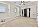 Spacious bedroom with a ceiling fan, carpet, and built in shelving space next to a closet at 4002 E Agave Rd, Phoenix, AZ 85044
