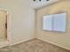 Bedroom with a window, neutral carpet, and a doorway leading to a connected room at 4002 E Agave Rd, Phoenix, AZ 85044