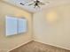 A sunlit bedroom with a ceiling fan, carpeted flooring, and a window with blinds at 4002 E Agave Rd, Phoenix, AZ 85044