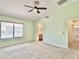 Main bedroom featuring an en suite bathroom, ceiling fan, and large windows at 4002 E Agave Rd, Phoenix, AZ 85044