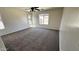 Bright bedroom with neutral carpet, a ceiling fan, and a window at 43890 W Bedford Dr, Maricopa, AZ 85138