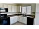 Bright kitchen with white cabinets, black appliances, a stainless steel sink, and a window at 43890 W Bedford Dr, Maricopa, AZ 85138